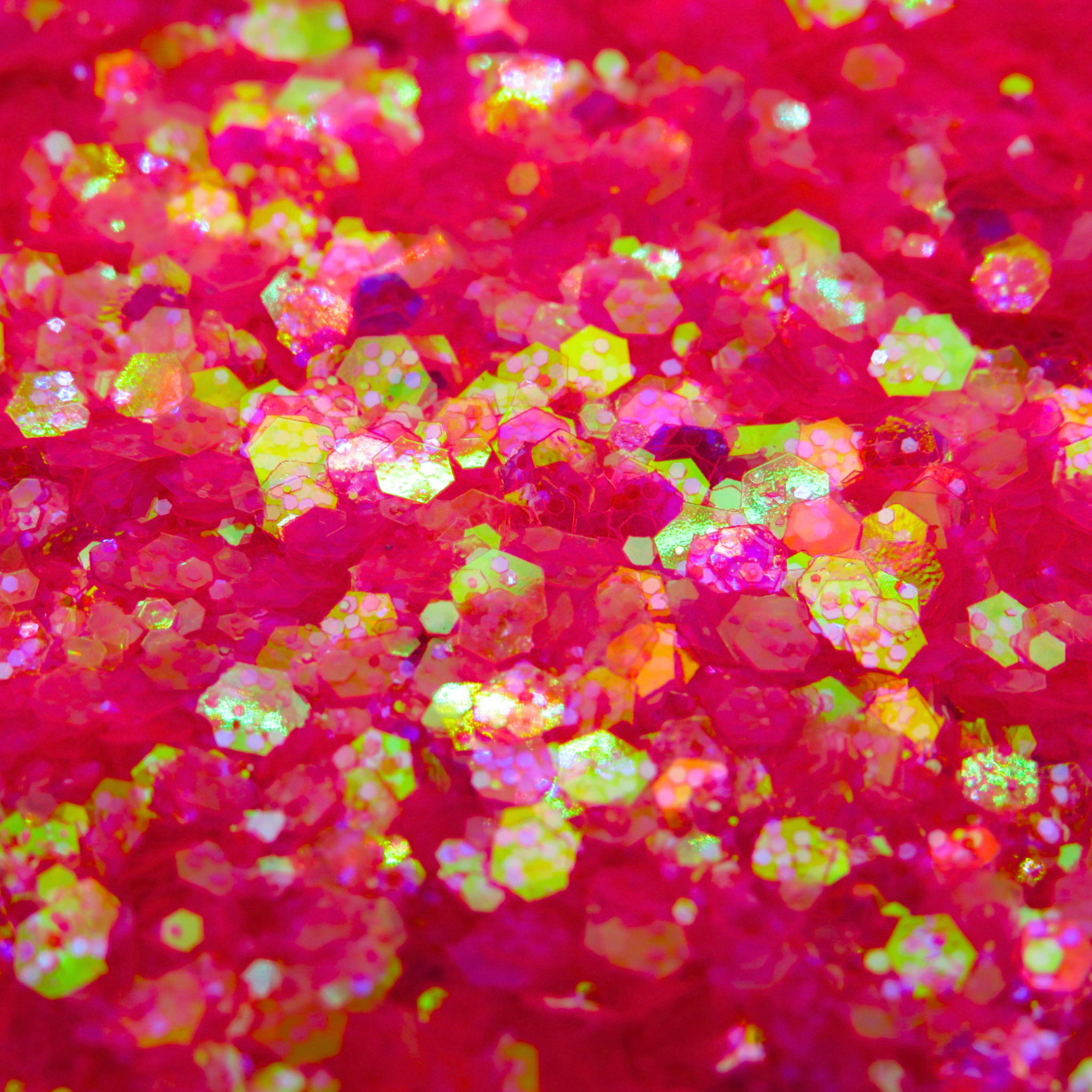 Peachipie pink iridescent glitter close up with yellow hues when the light catches it.